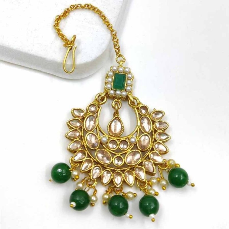 Green colour wonderful classy traditional mang tikka form kayaa fashion for stylish women like you. It is wonderfully styled with stone and made form metal. This classy mang tikka has pearls beads droplets for stylish look. Buy now!