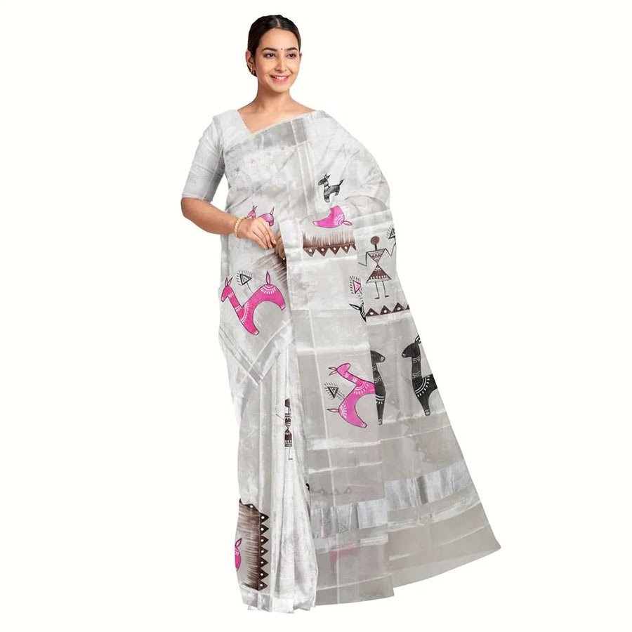 Silver zari saree with tribal art FAD s will never ,ever be able to replace the attention and charm of steady , handcrafted creations of rural artisans. This Kerala silver zari saree is hand-painted with bright hues and traditional design elements that reflect the rich, vibrant Indian tribal culture. Ekatva launching a classic piece of art from the rural artisans of Madhya Pradesh.