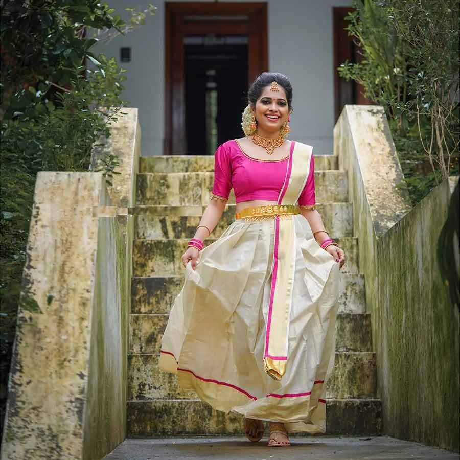 A timeless design featuring a pink bodice uplifted with intricate hand embroidery and crystals, tissue kasavu pleated skirt and a sublime kasavu dupatta. A perfect ethnic pick for your wedding/ sangeet event.