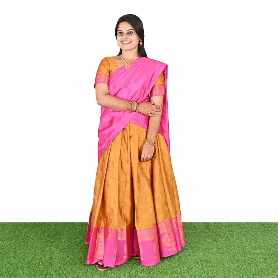An ode to south Indian classic drapes. An exquisite half saree in a festive combination of hues. A versatile drape with an ethnic skirt and matching bodice teamed with a wispy vibrant dupatta that can be styled in multiple ways and have all eyes on you.